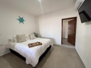 Un dormitorio con una cama y una bandeja. en Departamentos DOS21, en Mazatlán