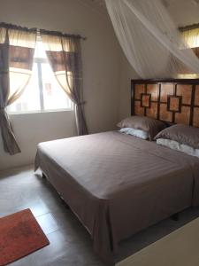 a bedroom with a large bed with a large window at Super breezy cozynook ! in Bridgetown