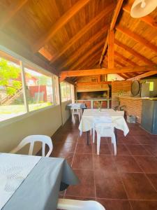 a dining room with white tables and white chairs at Complejo El Faro in Santa Rosa de Calamuchita