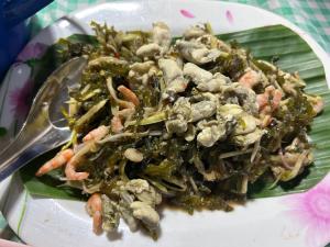 um prato de alimentos com camarão e vegetais numa folha de banana em Baan Plai Laem Homesty em Koh Phaluai
