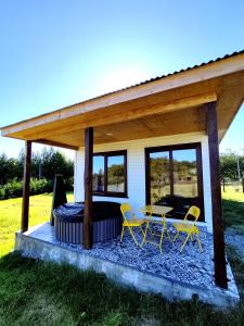 a pavilion with a table and chairs in front of a house at Casa Rayen Puerto Varas in Puerto Varas