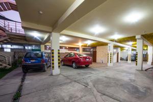 two cars parked in a parking lot in a building at HOTEL KALIXTO in Cayma