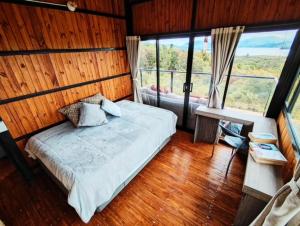 sypialnia z łóżkiem w pokoju z oknami w obiekcie Sans Souci - Cabaña w mieście La Unión