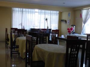 a dining room with tables and chairs and a window at HOTEL KALIXTO in Cayma