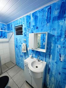 Casa sambaqui في فلوريانوبوليس: حمام أزرق مع حوض ومرآة