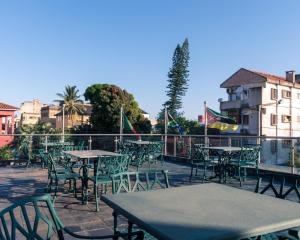 um pátio vazio com mesas, cadeiras e bandeiras em Hotel Monte Carlo em Maputo