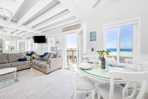 een woonkamer met een tafel en stoelen en de oceaan bij Stunning Ocean Views - Recently Renovated Home & Warm Sunsets in San Diego