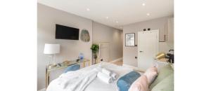 a person laying on a bed in a room at Nestled Nook: Charming Studio For Couples in London