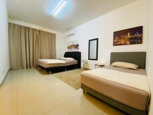 pokój hotelowy z 2 łóżkami i oknem w obiekcie Alyn Home Kluang I Netflix Wifi Coway w mieście Kluang