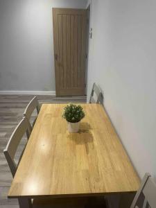 a wooden table with a potted plant on top of it at COSY 1 -The Lodge in Bury