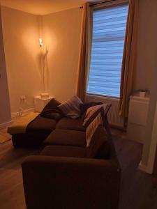 a living room with a couch and a window at COSY 1 -The Lodge in Bury