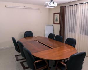 una sala de conferencias con mesa de madera y sillas en Hotel Monte Carlo, en Maputo