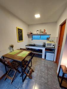 a kitchen with a table and a stove top oven at Urutau Loft in Puerto Iguazú
