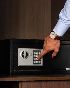 a person with a watch on top of a microwave at Hotel Monte Carlo in Maputo