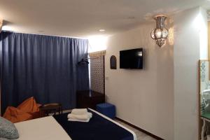 a bedroom with a bed and a tv on the wall at Al-Andalus hause a 9min. del centro en metro in San Juan de Aznalfarache