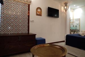 a living room with a tv and a table in a room at Al-Andalus hause a 9min. del centro en metro in San Juan de Aznalfarache