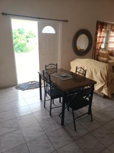 a living room with a table and chairs and a bed at Super breezy cozynook ! in Bridgetown