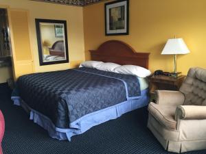 a hotel room with a bed and a chair at Norwalk Inn in Norwalk
