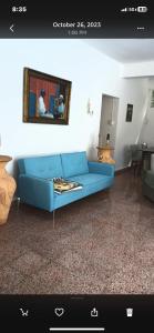 una sala de estar con un sofá azul en una habitación en Playa Alejandra, 