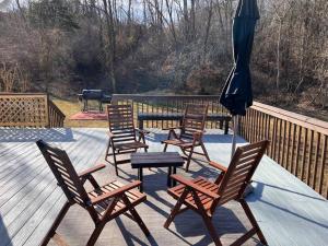 a group of chairs and an umbrella on a deck at The Basye House - Secluded Mountain Valley Getaway in Basye