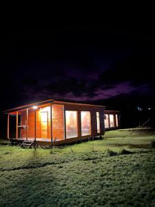 a small wooden cabin in a field at night at Cabañas Brisas del Mar- Hualaihue in Hualaihué