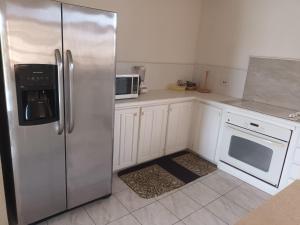 a kitchen with a stainless steel refrigerator and a dishwasher at Super breezy cozynook ! in Bridgetown +15 photos