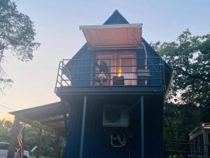ein blaues Haus mit einer Person, die in einem Turm sitzt in der Unterkunft Bastrop Tiny Disc Golf Retreat in Bastrop