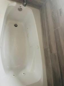 a white bath tub in a bathroom with wooden floors at Bastrop Tiny Disc Golf Retreat in Bastrop