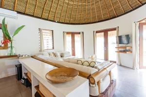 ein Wohnzimmer mit einem Sofa und einem Tisch in der Unterkunft Acacia Bungalows Bingin in Uluwatu