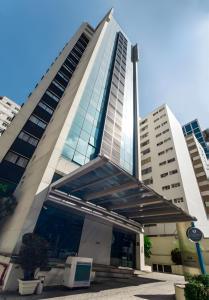 a tall building with a revolving door in front of it at Cyclinn Bela Cintra Jardins in Sao Paulo