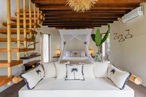 una camera con letto bianco e cuscini di Acacia Bungalows Bingin a Uluwatu