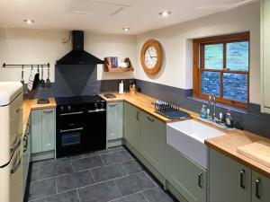 a kitchen with a sink and a clock on the wall at Coed Mawr in Betws-y-coed