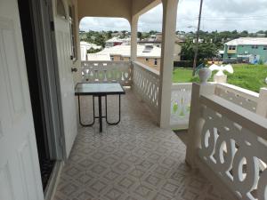 um alpendre com uma mesa e uma vista em Super breezy cozynook ! em Bridgetown