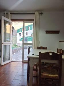 una cocina con mesa y sillas y una puerta corredera de cristal en Penitentes departamento en Los Penitentes