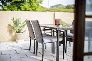 - une table et des chaises noires sur la terrasse dans l'établissement Rockingham Beach Breeze 2br Retreat, à Rockingham