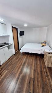 1 dormitorio con 1 cama y suelo de madera en Hostal Vicmar, en Viña del Mar