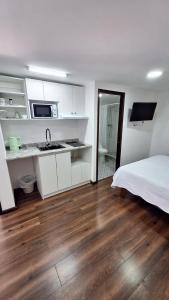 a bedroom with white cabinets and a wooden floor at Hostal Vicmar in Viña del Mar