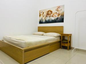 Alyn Home Kluang I Netflix Wifi Coway في كلوانج: سرير في غرفة مع صورة على الحائط