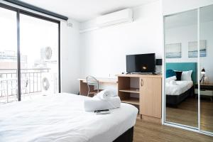 een hotelkamer met een bed en een televisie bij Urban Oasis On Victoria Avenue in Perth