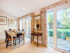 a dining room with a table and a large window at The Stables in Crockham Hill