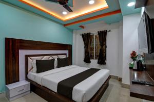 a bedroom with a large bed with a ceiling at Super OYO AIRPORT PALACE in kolkata