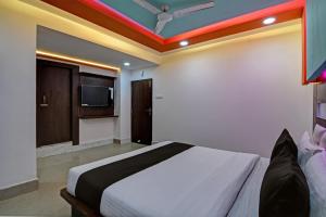 a bedroom with a bed and a tv on the ceiling at Super OYO AIRPORT PALACE in kolkata