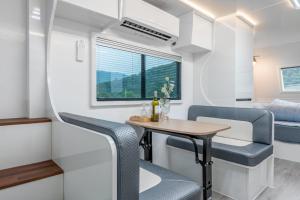a small table and chairs in a tiny caravan at Chuncheon Healing Bridge in Chuncheon