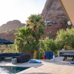 a patio with a pool table and chairs and a mountain at Multi-Million Dollar Luxury Estate, Heated Pool, City Views in Phoenix