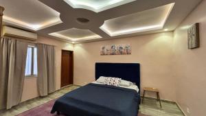 a bedroom with a blue bed and a ceiling at Magnifique appartement meublé à Dakar, Rte de Rufisque in Dakar