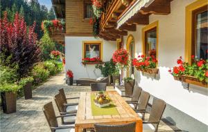a patio with a table and chairs and flowers at Amazing Apartment In Mhlbach With 2 Bedrooms in Mühlbach am Hochkönig