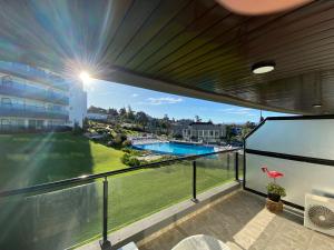 balcón con vistas a la piscina en Veneto Departamento Complejo Vacacional y Spa PB en Villa Santa Cruz del Lago