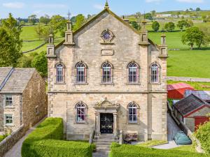 an old stone house with a staircase leading to it at Dales Chapel in Middleton in Teesdale