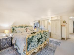 a bedroom with a large bed with a floral bedspread at Spring Cottage in Sedgeford