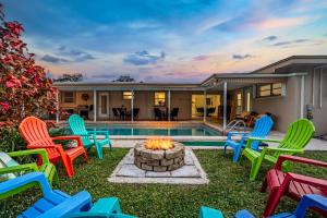 a backyard with colorful chairs and a fire pit at Music Lovers Villa, 4BD, 3BA, Pool, Game Room Outdoor Projector in Pembroke Pines